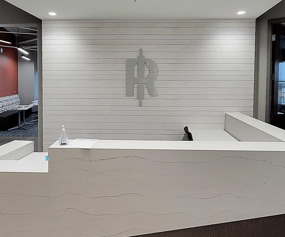 Interior Logo R and rolling pin logo behind reception area on white wooden wall